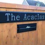 W3-3 Gate Mounted External Post Box installed in a wooden fence below a customer name plate