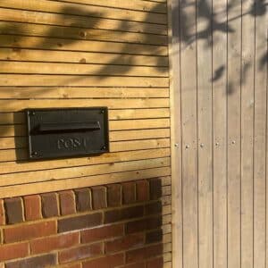 Cast Aluminium Letter Plate For Gates Nero Lifestyle Image on Wall with Gate Through Wall Letterboxes LFD 041 Nero Letterplate